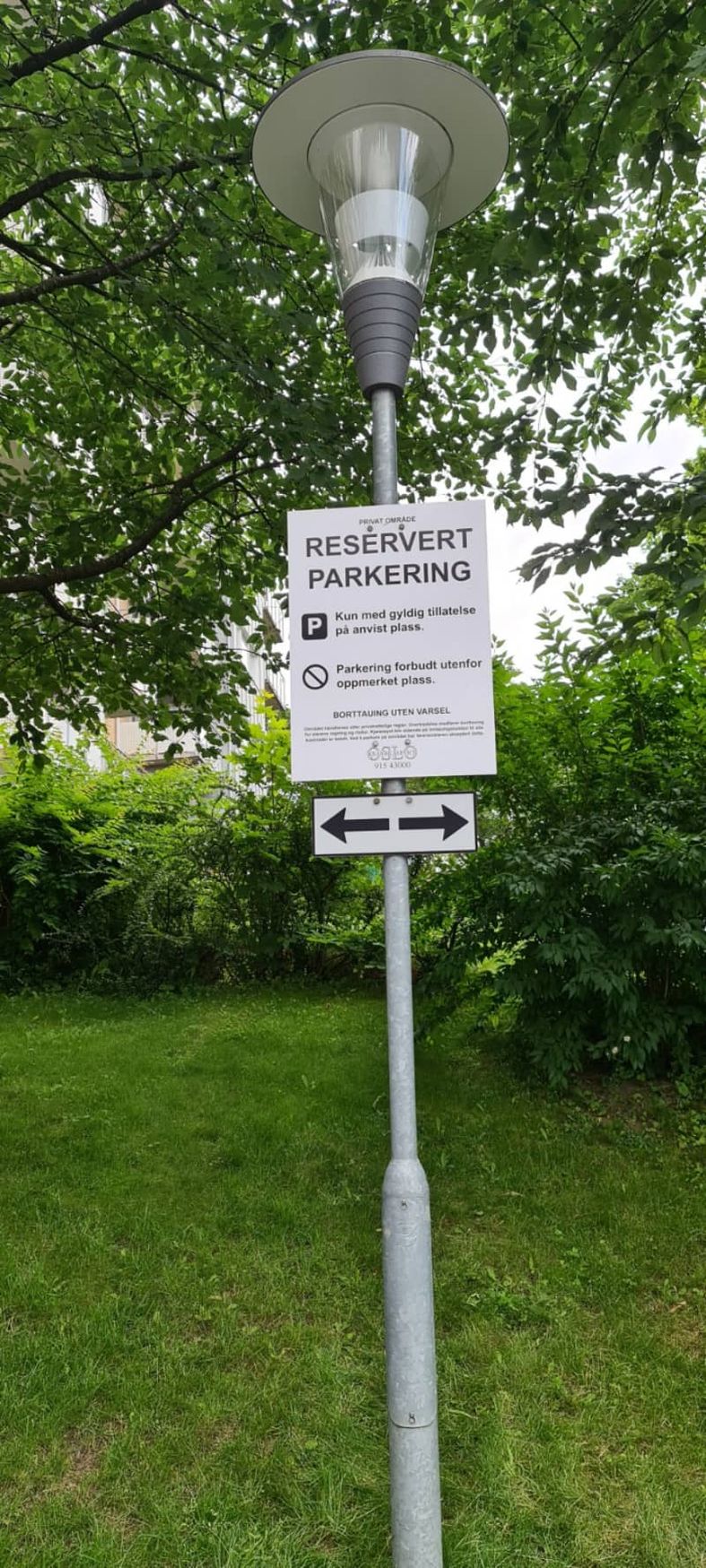 Reservert parkering-skilt på lampe